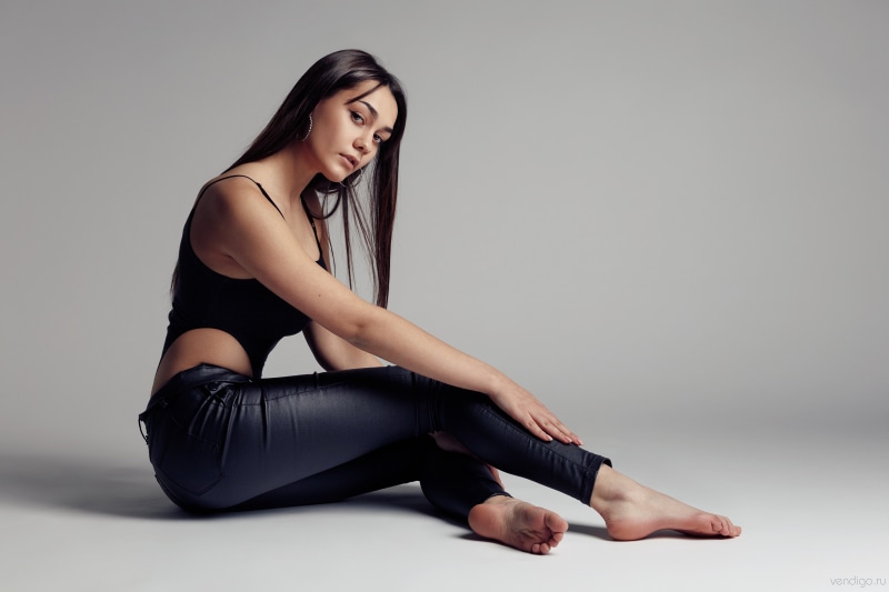 Kristina sitting in black singlet and trousers