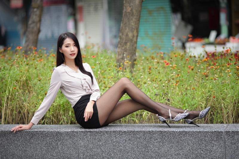 Asian woman in blouse and skirt posing