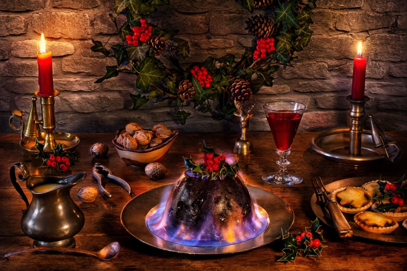 Christmas pudding with flaming brandy, nuts, and mince pies
