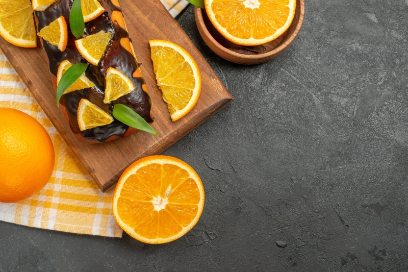 Chocolate pound cake with orange slices on a cutting board