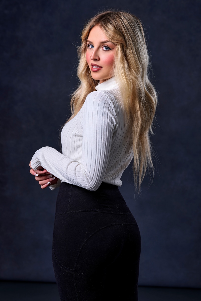 Blonde woman in white sweater and black pants