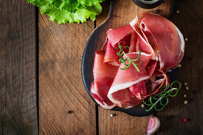 4K Ham Slices on Cutting Board with Garlic and Lettuce