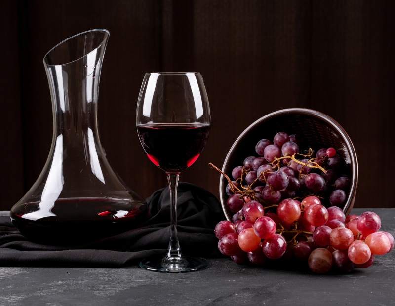 Red wine in a decanter and glass with grapes
