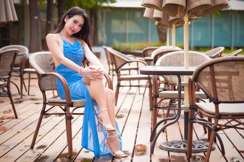 Asian woman in blue dress sitting on chair