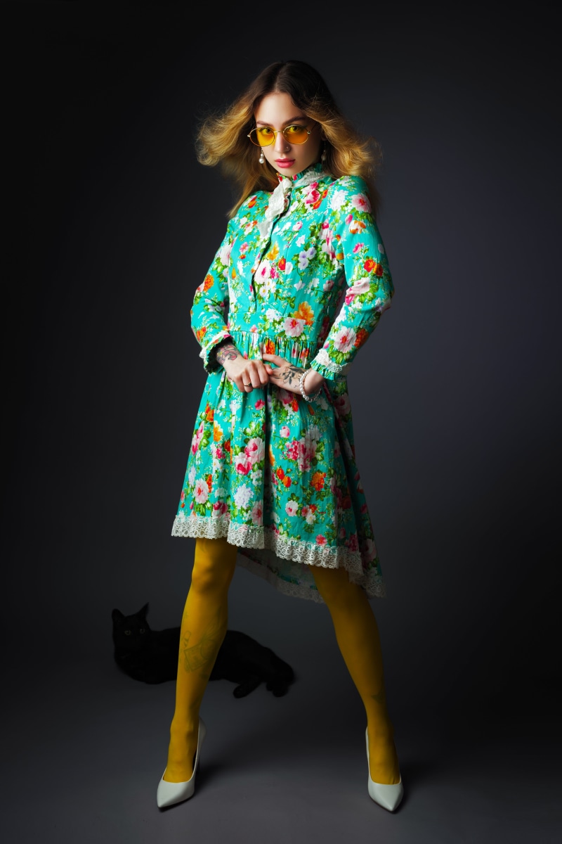 Woman in floral dress with yellow pantyhose and cat