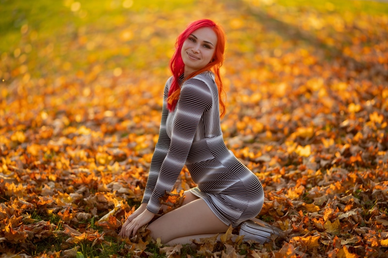Redhead girl Denise sitting in foliage