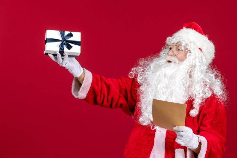 Santa Claus holding a gift and a letter