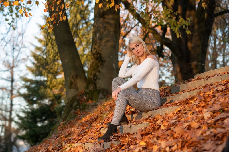 Vanessa sitting on stairs in autumn foliage