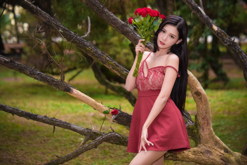 Asian woman with roses in a forest