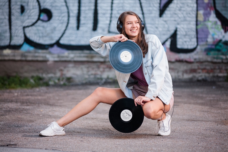 Girl with headphones holding vinyl records