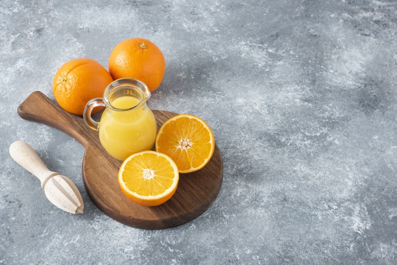 Oranges and orange juice on a cutting board