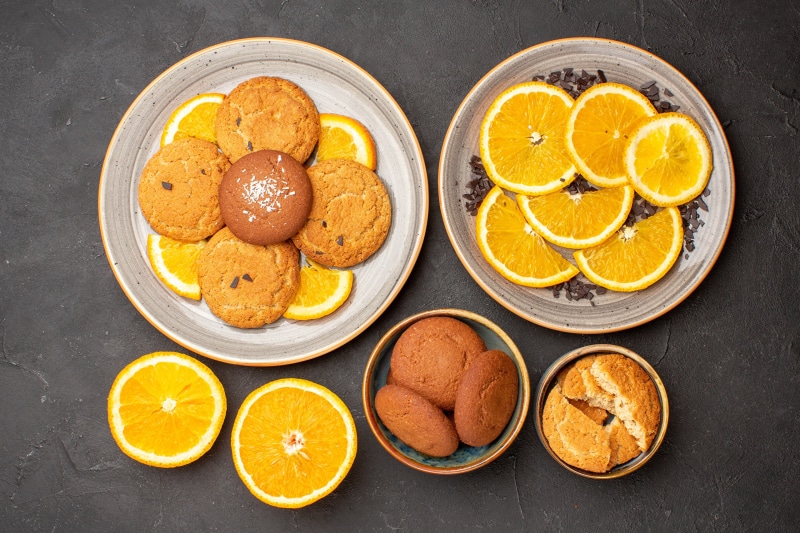 Cookies and orange slices on plates
