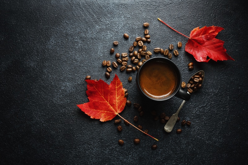 Coffee cup with beans and autumn leaves