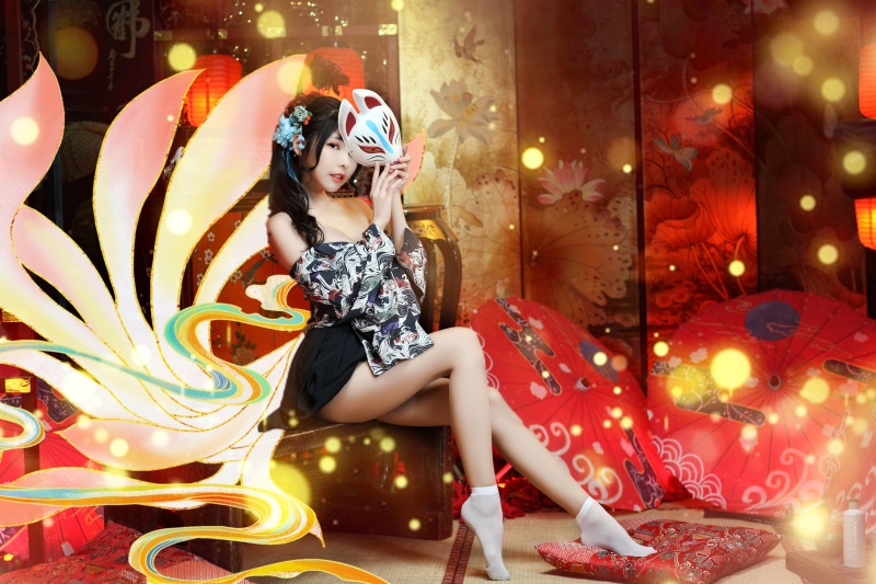 Asian woman in kimono holding a fox mask