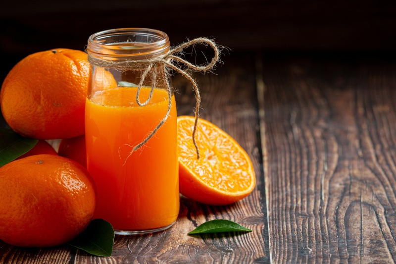 Orange juice in a jar with oranges