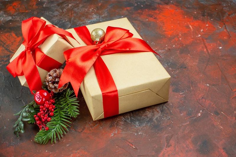 Christmas gifts with red ribbons and pine cones
