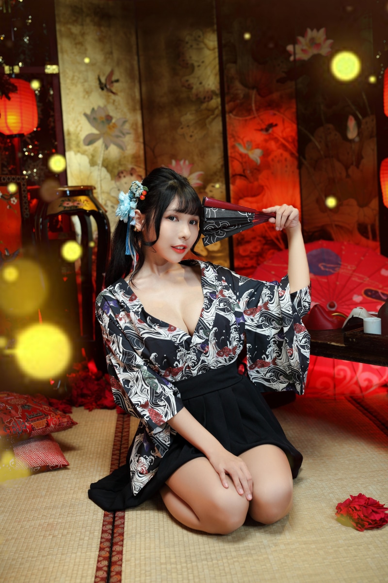 Brunette girl in kimono holding a hand fan