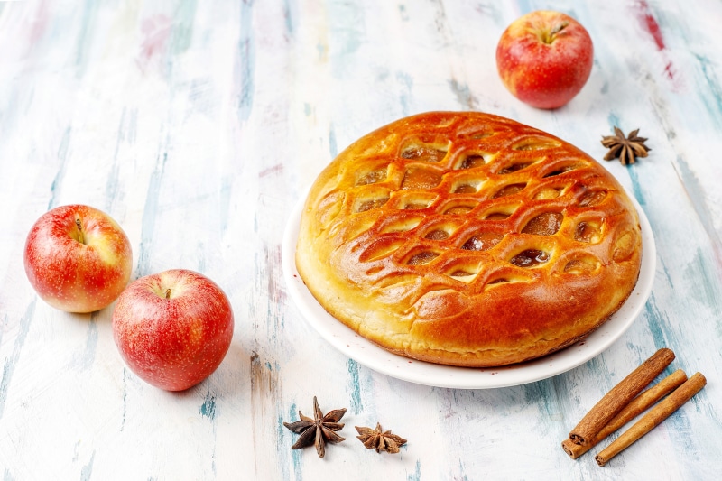 Apple pie with apples and cinnamon sticks
