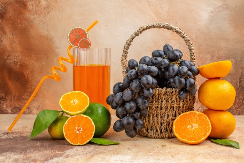 Grapes, Oranges, Mandarines, and Orange Juice in a Glass