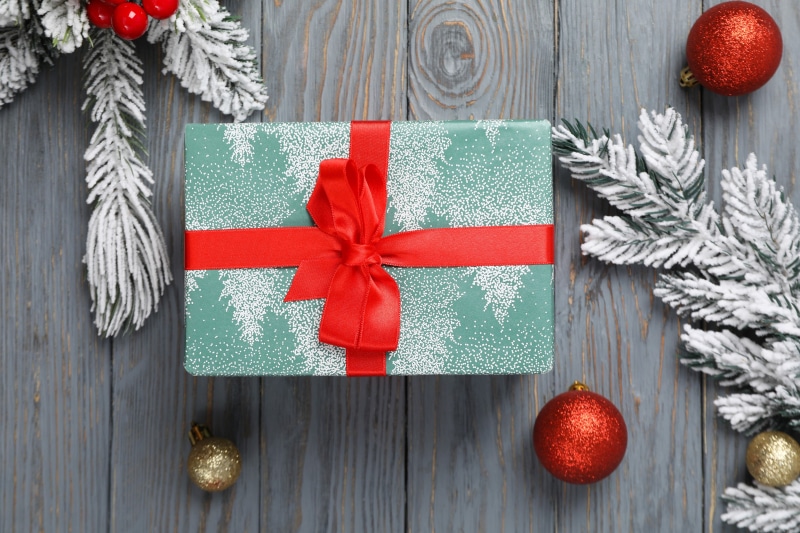 Christmas gift box with red ribbon and ornaments