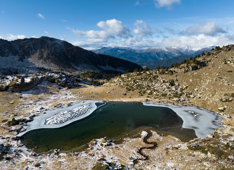 Frozen mountain lake in Andorra with snowy peaks