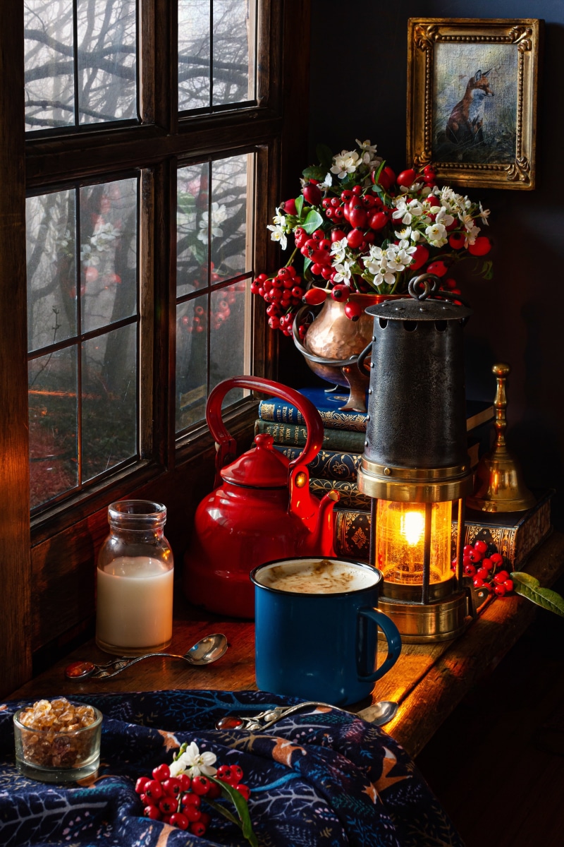 Still life with red kettle, coffee mug, and kerosene lamp