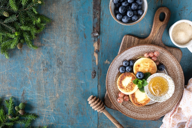 Cheesecakes with blueberries, currants, and honey on a plate