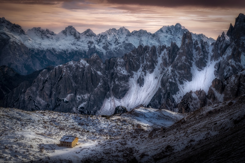 Small house in snowy Italian Alps mountains