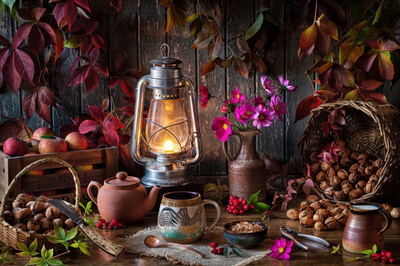 Autumn still life with kerosene lamp, apples, and walnuts