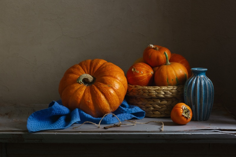 Still-life with pumpkins, persimmon, and blue vase