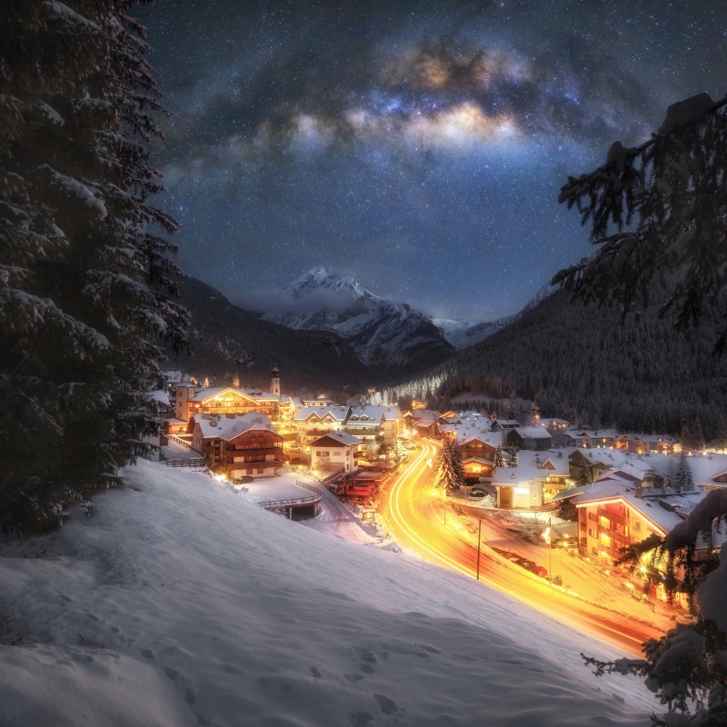 Winter village under the Milky Way in the Alps