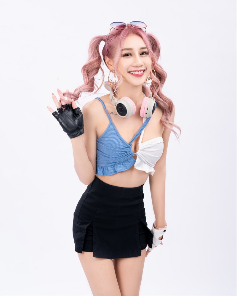 Asian woman with pink hair wearing headphones and a skirt
