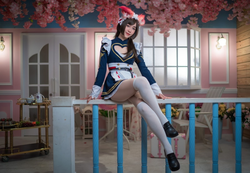 Asian girl in maid cosplay sitting on railing