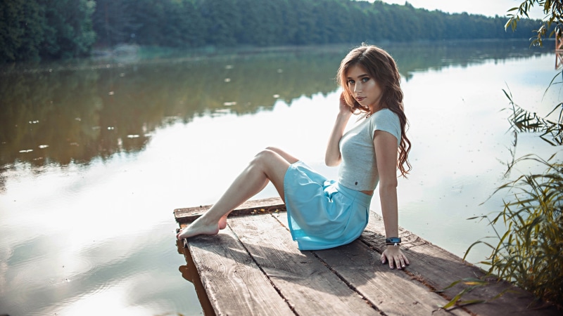 Anna Stolyar sitting on a dock by a river