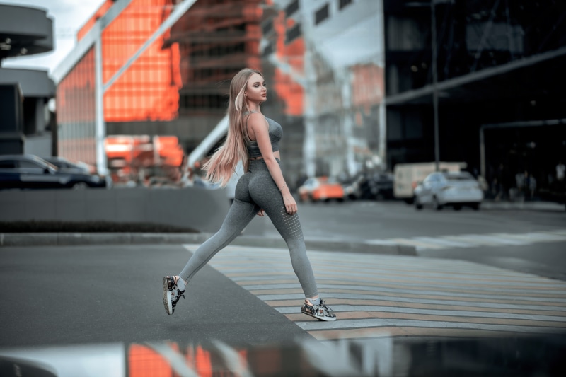 Woman in fitness attire walking on a crosswalk