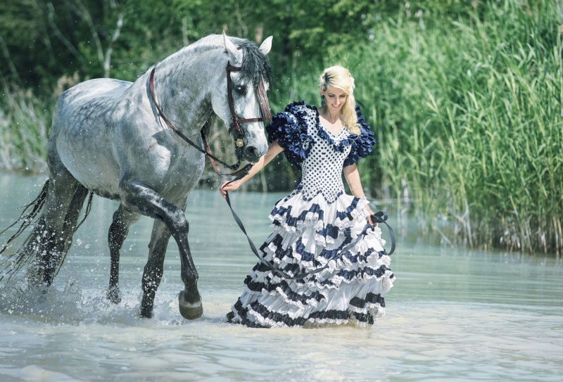 Blonde girl with horse in water