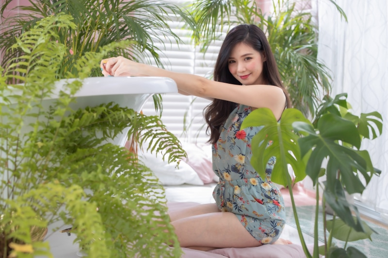 Asian woman posing among plants