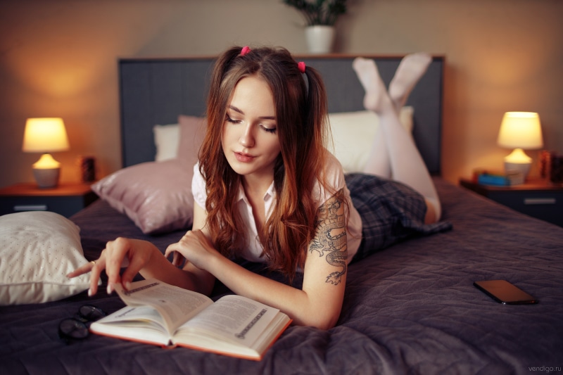 Natalia Vasilyeva reading a book on a bed