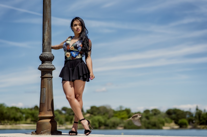 Brunette girl posing by a lamppost