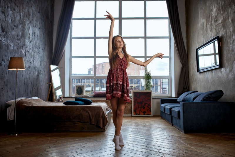 Woman in dress dancing in a loft apartment