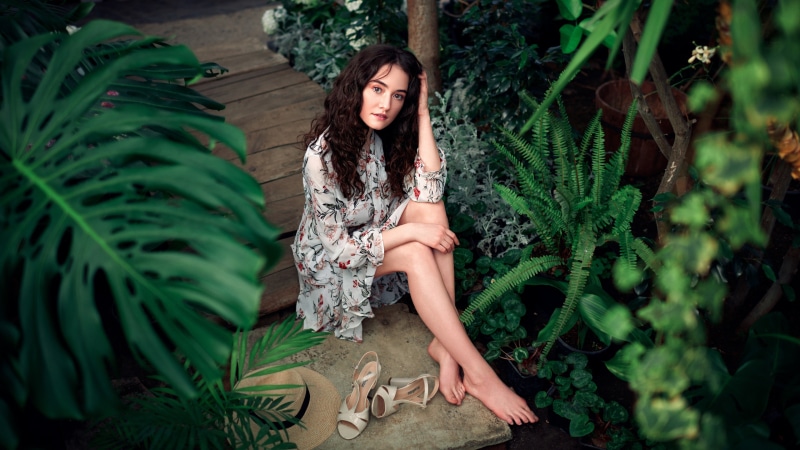 Alice Musina sitting in a garden with plants