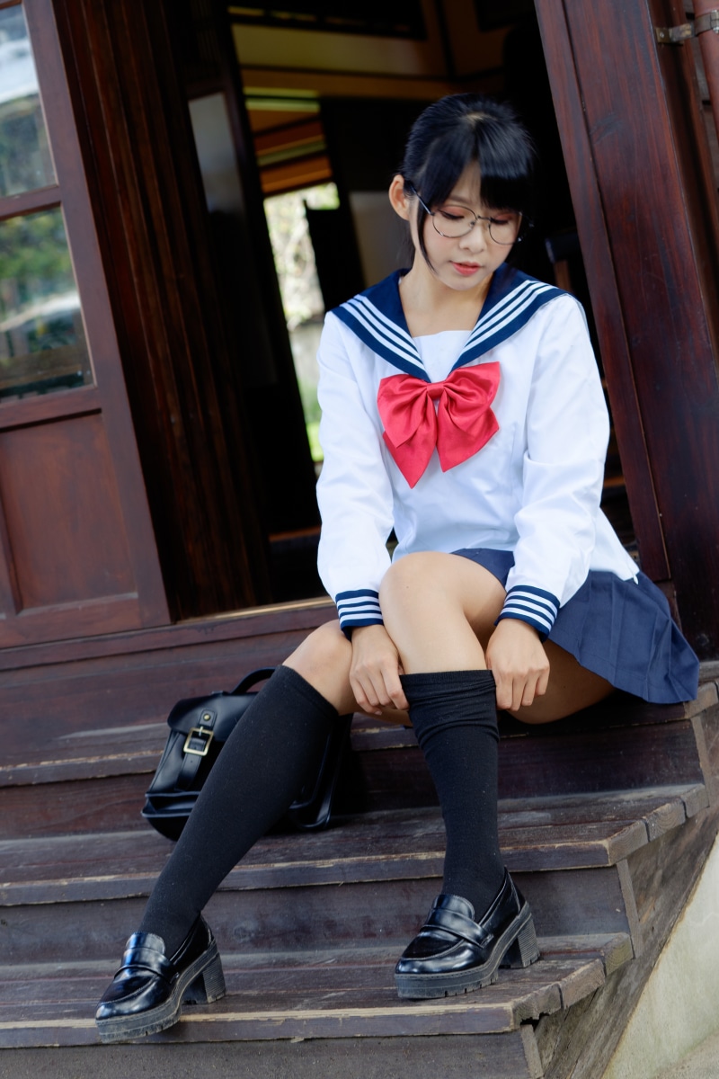 Asian girl in school uniform sitting on stairs