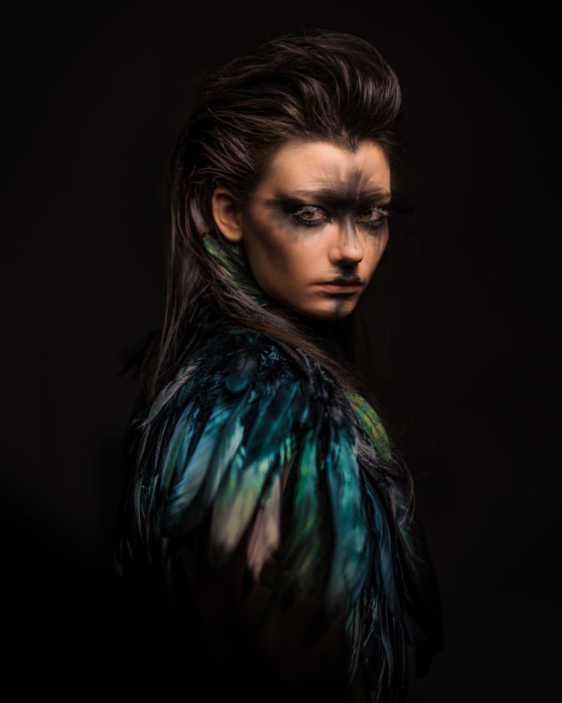Woman with dramatic makeup and feather accessory