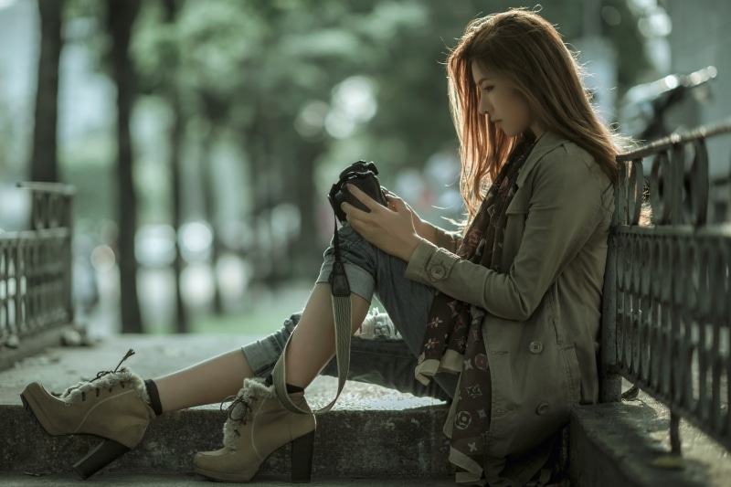 Woman with camera sitting on steps
