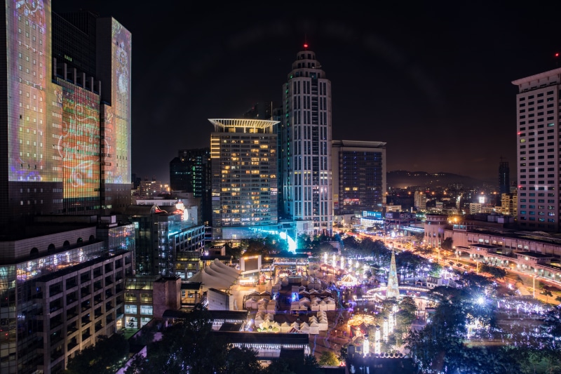 Cityscape at night with illuminated buildings and a fairground