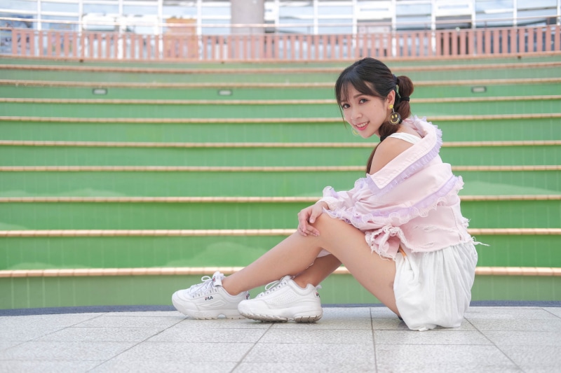 Asian woman sitting on steps wearing athletic shoes