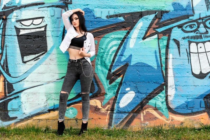 Woman posing in front of graffiti wall