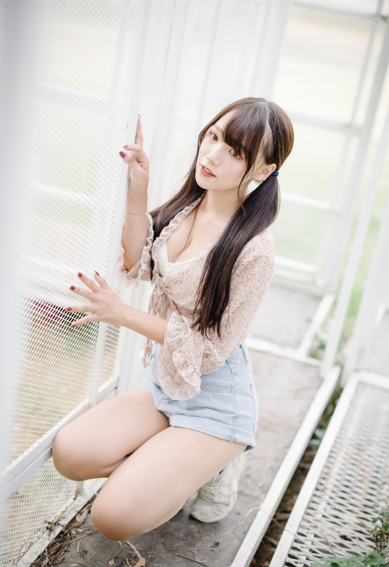 Asian girl with pigtails wearing floral top and shorts