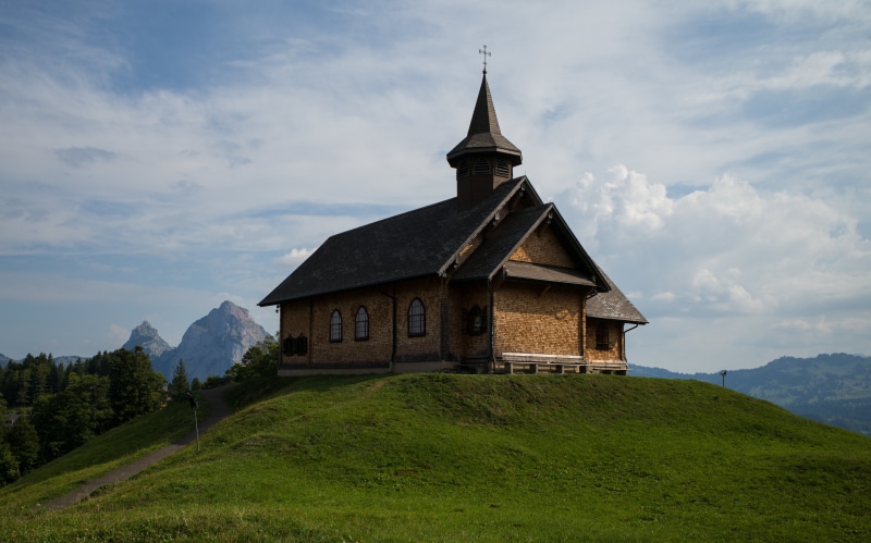 Wooden church on a grassy hill in Stoos, Switzerland