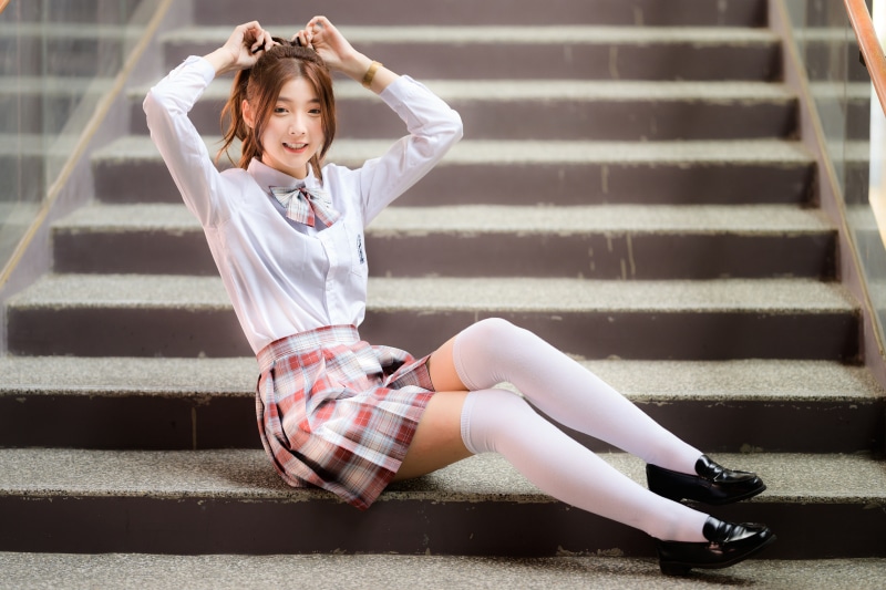 Asian girl in school uniform sitting on stairs